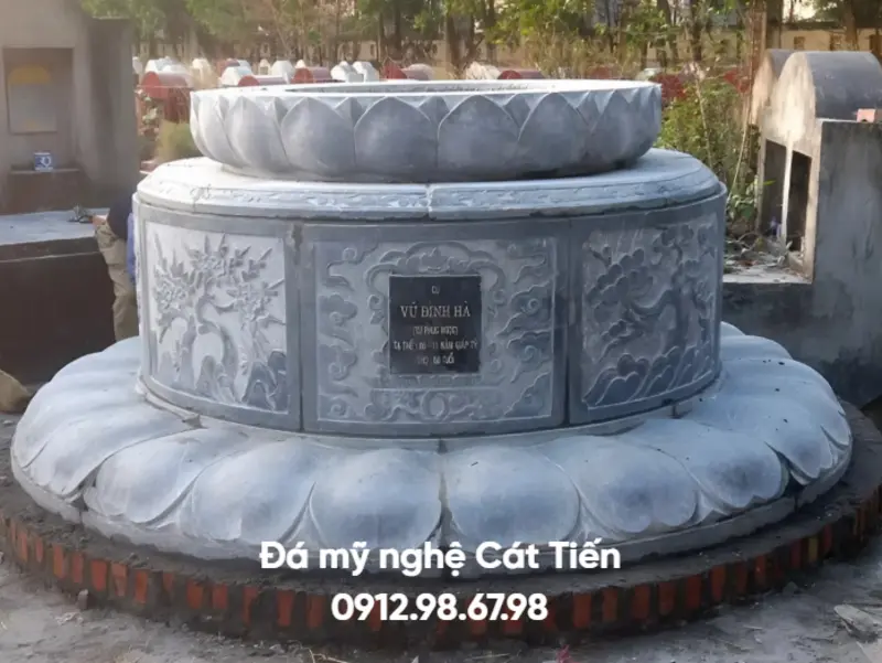 Đá mỹ nghệ Cát Tiến cung cấp mẫu mộ đá tròn được chế tác từ đá xanh đen, phần chân đế chạm khắc cánh sen lớn
